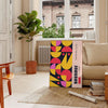 Poster showing abstract Bauhaus geometric artwork in yellow and black - in a Parisian living room with a sofa and a fig plant