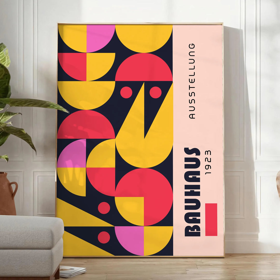 Poster showing abstract Bauhaus geometric artwork in yellow and black - in a bright minimalist room with a plant and an armchair