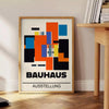 Plakat Bauhaus z geometrycznymi abstrakcyjnymi formami, nowoczesny minimalizm - obok okrągłego drewnianego stolika z książkami