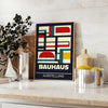Bauhaus-Plakat mit abstrakter geometrischer Komposition in Grün und Rot - auf einer Arbeitsplatte mit Eukalyptus und einer Schale Zitronen
