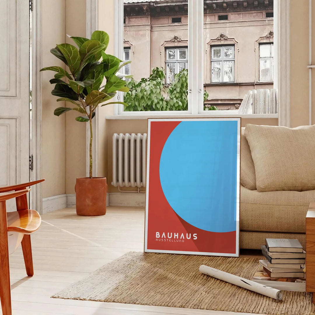 Plakāts ar Bauhaus ģeometrisku abstraktu kompozīciju minimālistiskā stilā - parīzīgā viesistabā ar dīvānu un fikusu