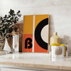 Brown and black geometric Bauhaus poster with minimalist abstract shapes - styled on a counter with eucalyptus and a bowl of lemons