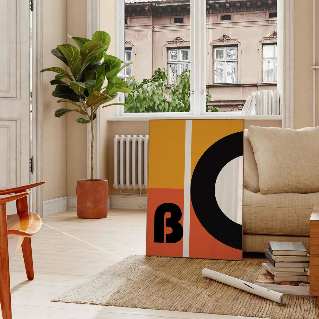 Brown and black geometric Bauhaus poster with minimalist abstract shapes - in a Parisian living room with a sofa and a fig plant