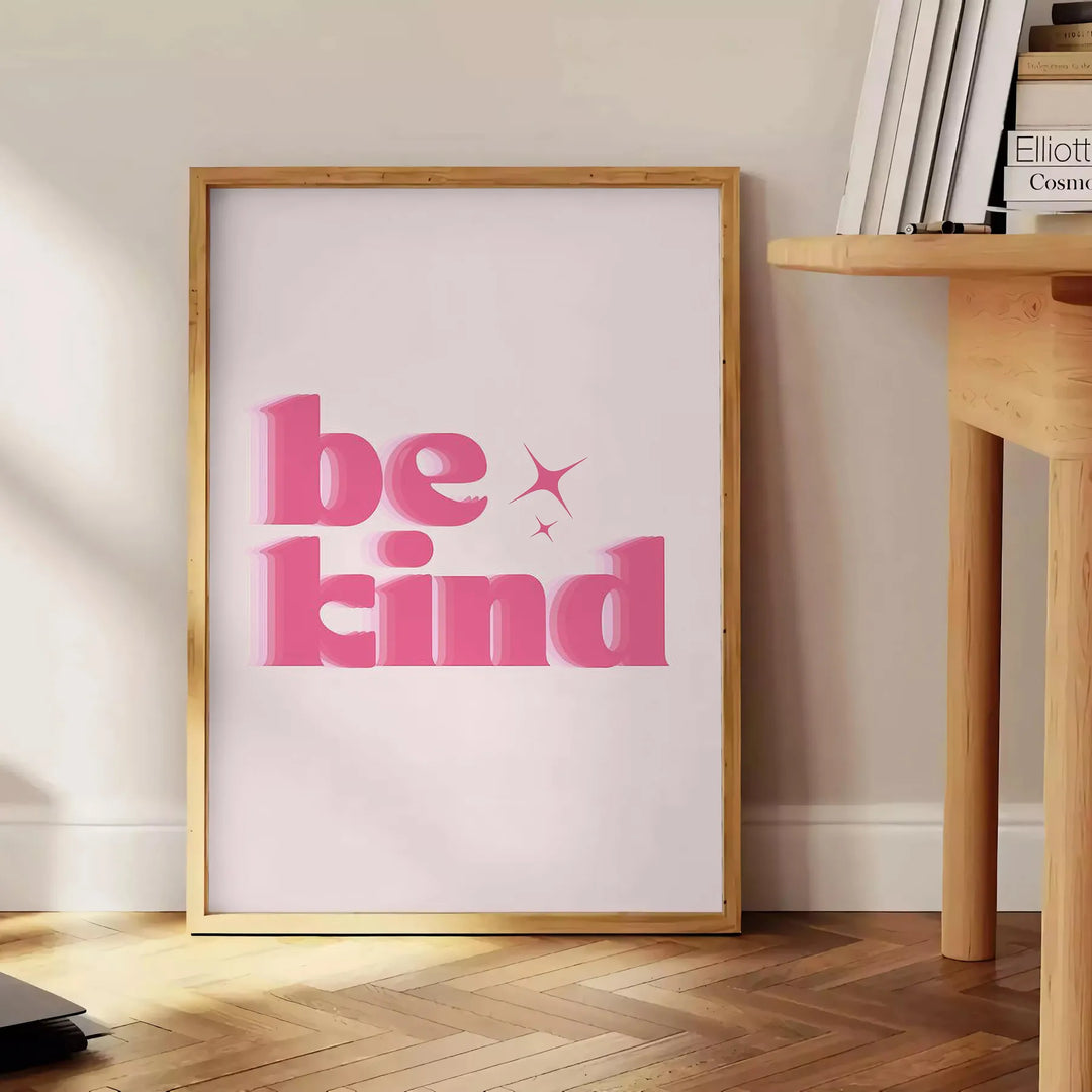 Colorful abstract design featuring the phrase 'Be Kind' in playful typography - beside a round wooden side table with books