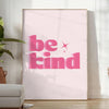 Colorful abstract design featuring the phrase 'Be Kind' in playful typography - in a bright minimalist room with a plant and an armchair