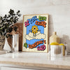A retro-style poster featuring a sun with groovy typography in orange and gray - styled on a counter with eucalyptus and a bowl of lemons