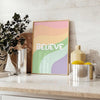 Abstract design with the word 'Believe' in green and orange hues - styled on a counter with eucalyptus and a bowl of lemons