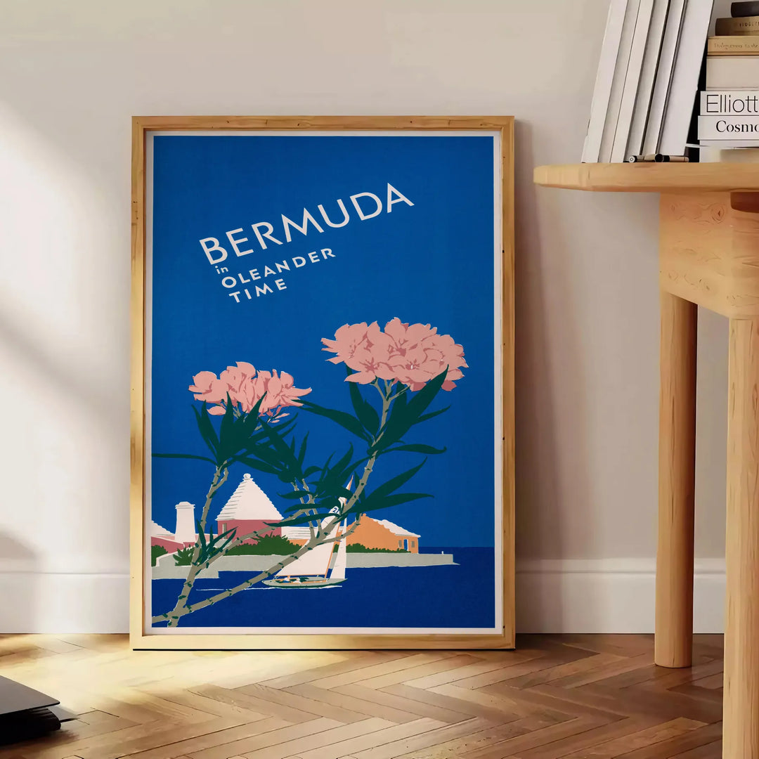 Bermuda travel poster featuring a serene beach scene with blue and green hues - beside a round wooden side table with books
