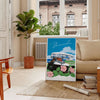 A vintage travel poster featuring Bermuda's coastline in muted gray and black tones - in a Parisian living room with a sofa and a fig plant