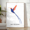 Colorful bird illustration with orange and blue hues on a dark background - in a bright minimalist room with a plant and an armchair