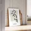 A bohemian-style poster featuring a bird in shades of gray and black - leaning on a herringbone floor against a white panelled wall