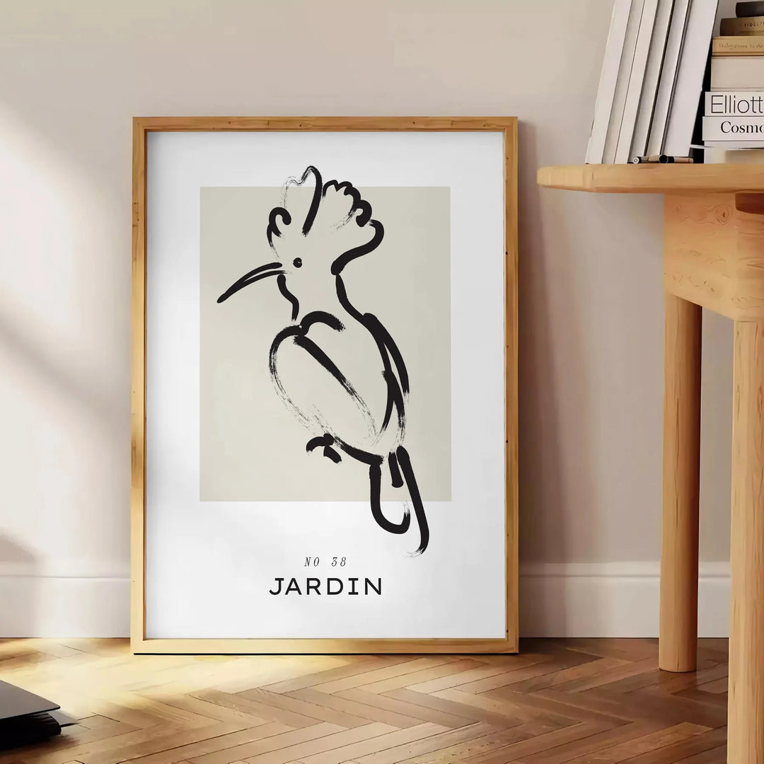 A bohemian-style poster featuring a bird in shades of gray and black - beside a round wooden side table with books