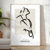 A bohemian-style poster featuring a bird in shades of gray and black - in a bright minimalist room with a plant and an armchair