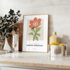 A close-up of colorful blossoms in shades of green and orange - styled on a counter with eucalyptus and a bowl of lemons