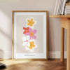 abstract flower design with black and orange hues - beside a round wooden side table with books