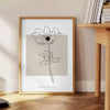 Design floral abstrato com flores laranjas e pretas - ao lado de uma mesa de apoio redonda em madeira com livros