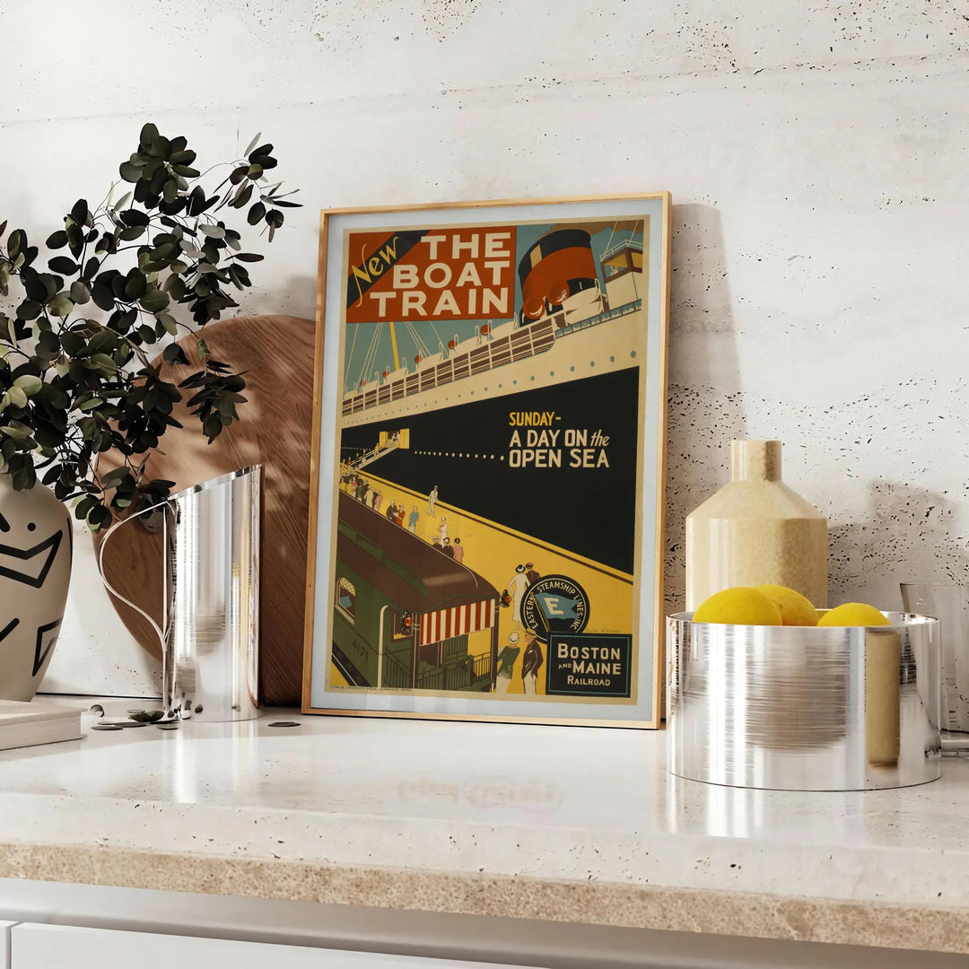 A stylized illustration of a boat sailing through blue waters with black accents - styled on a counter with eucalyptus and a bowl of lemons