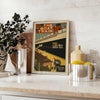 A stylized illustration of a boat sailing through blue waters with black accents - styled on a counter with eucalyptus and a bowl of lemons