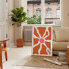 Abstract shapes in warm browns and oranges with a bohemian style - in a Parisian living room with a sofa and a fig plant