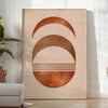 Abstract shapes in earthy browns and greens with a boho style - in a bright minimalist room with a plant and an armchair