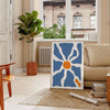 Abstrakte Boho-Kunst mit bunten Formen und Mustern - in einem Pariser Wohnzimmer mit Sofa und einer Geigenfeige