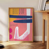Abstract design featuring orange and blue shapes with a bohemian style - beside a round wooden side table with books
