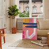 Abstract design featuring orange and blue shapes with a bohemian style - in a Parisian living room with a sofa and a fig plant