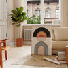 Abstract bohemian design with earthy tones and fluid shapes - in a Parisian living room with a sofa and a fig plant