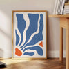 Abstract bohemian design featuring gray and orange hues - beside a round wooden side table with books
