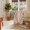 Design abstrato boho com tons terrosos e formas orgânicas - numa sala parisiense com sofá e um ficus