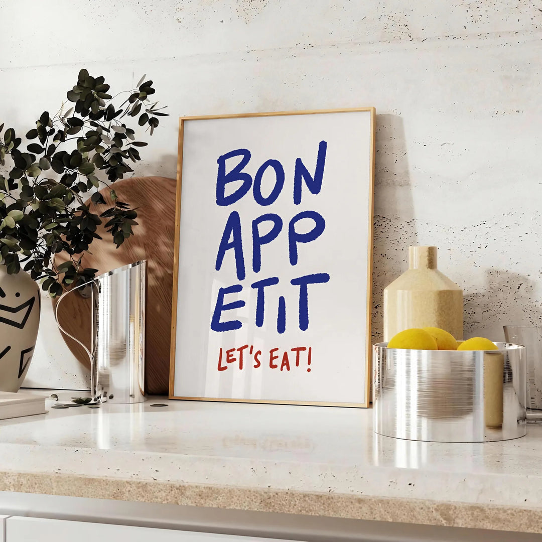 Kitchen scene with 'Bon Appetit' text in blue and gray tones - styled on a counter with eucalyptus and a bowl of lemons