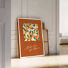 Vintage botanical illustration featuring various green plants and orange flowers - leaning on a herringbone floor against a white panelled wall