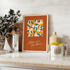 Vintage botanical illustration featuring various green plants and orange flowers - styled on a counter with eucalyptus and a bowl of lemons