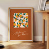 Vintage botanical illustration featuring various green plants and orange flowers - beside a round wooden side table with books
