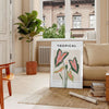 Botanical art print featuring orange and gray foliage in a modern style - in a Parisian living room with a sofa and a fig plant