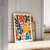 Botanische Illustration mit üppigem grünem Laub und warmen orangefarbenen Akzenten - an eine weiße Paneelwand gelehnt auf Fischgrätparkett