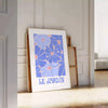 Vintage botanische Illustration mit blauen und weißen Blumen auf einem strukturierten Hintergrund - an eine weiße Paneelwand gelehnt auf Fischgrätparkett