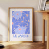 Vintage botanische Illustration mit blauen und weißen Blumen auf einem strukturierten Hintergrund - neben einem runden Beistelltisch aus Holz mit Büchern