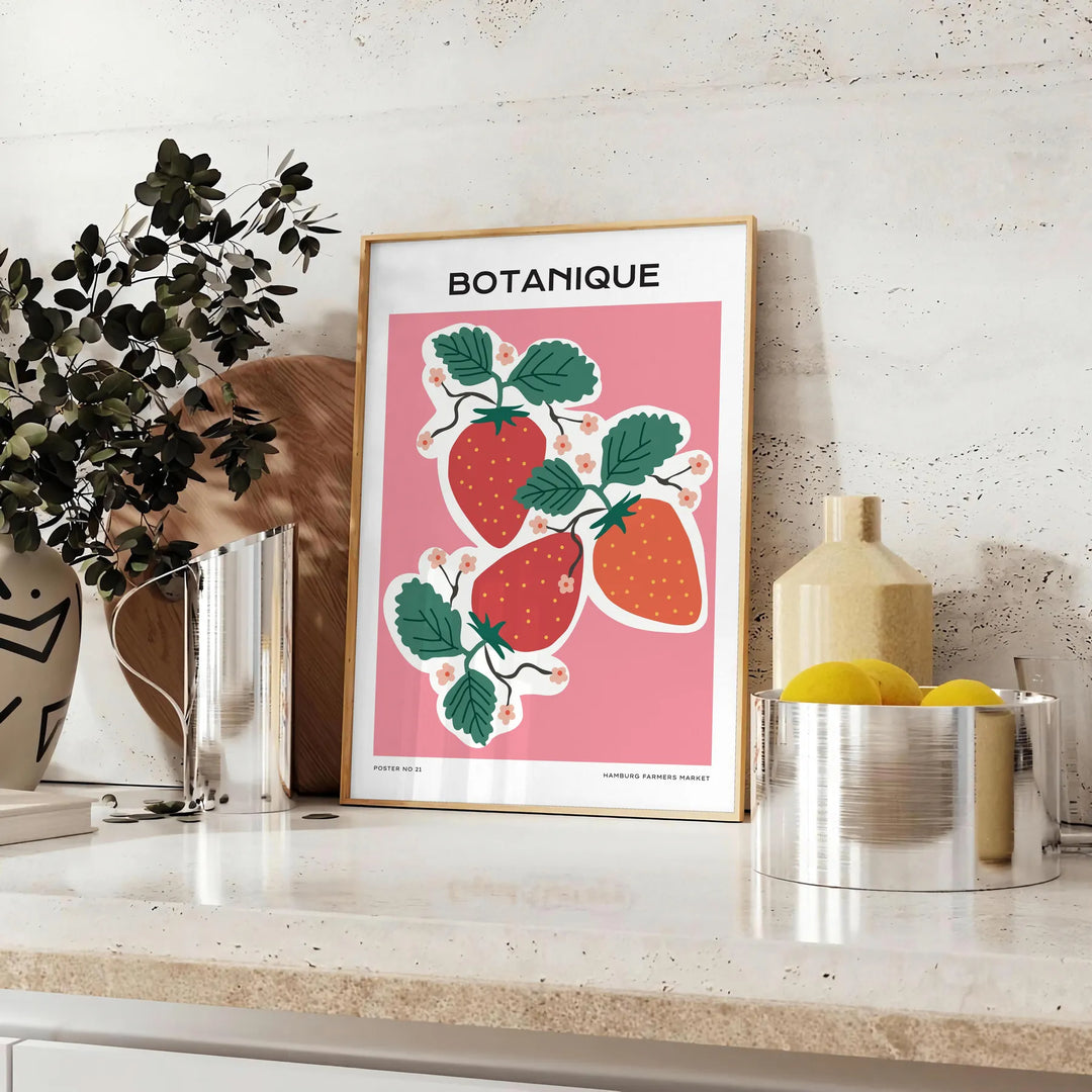 A vintage botanical print featuring orange and blue hues with various plants. - styled on a counter with eucalyptus and a bowl of lemons