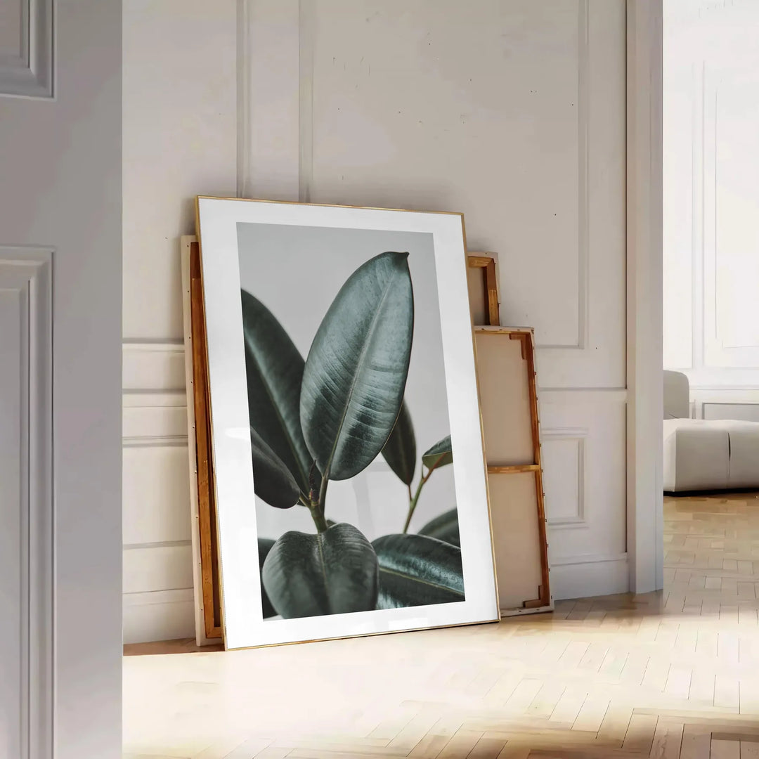 Vintage botanisches Foto mit üppigem grünem Laub vor einem ruhigen blauen Hintergrund - an eine weiße Paneelwand gelehnt auf Fischgrätparkett