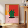 Botanical illustration featuring green leaves and orange flowers on a light background - beside a round wooden side table with books