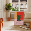 Botanical illustration featuring green leaves and orange flowers on a light background - in a Parisian living room with a sofa and a fig plant