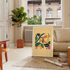 Botanical print featuring yellow flowers with bold black details - in a Parisian living room with a sofa and a fig plant