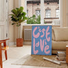 Abstract design with brown and green tones featuring the phrase 'C'est La Vie' - in a Parisian living room with a sofa and a fig plant