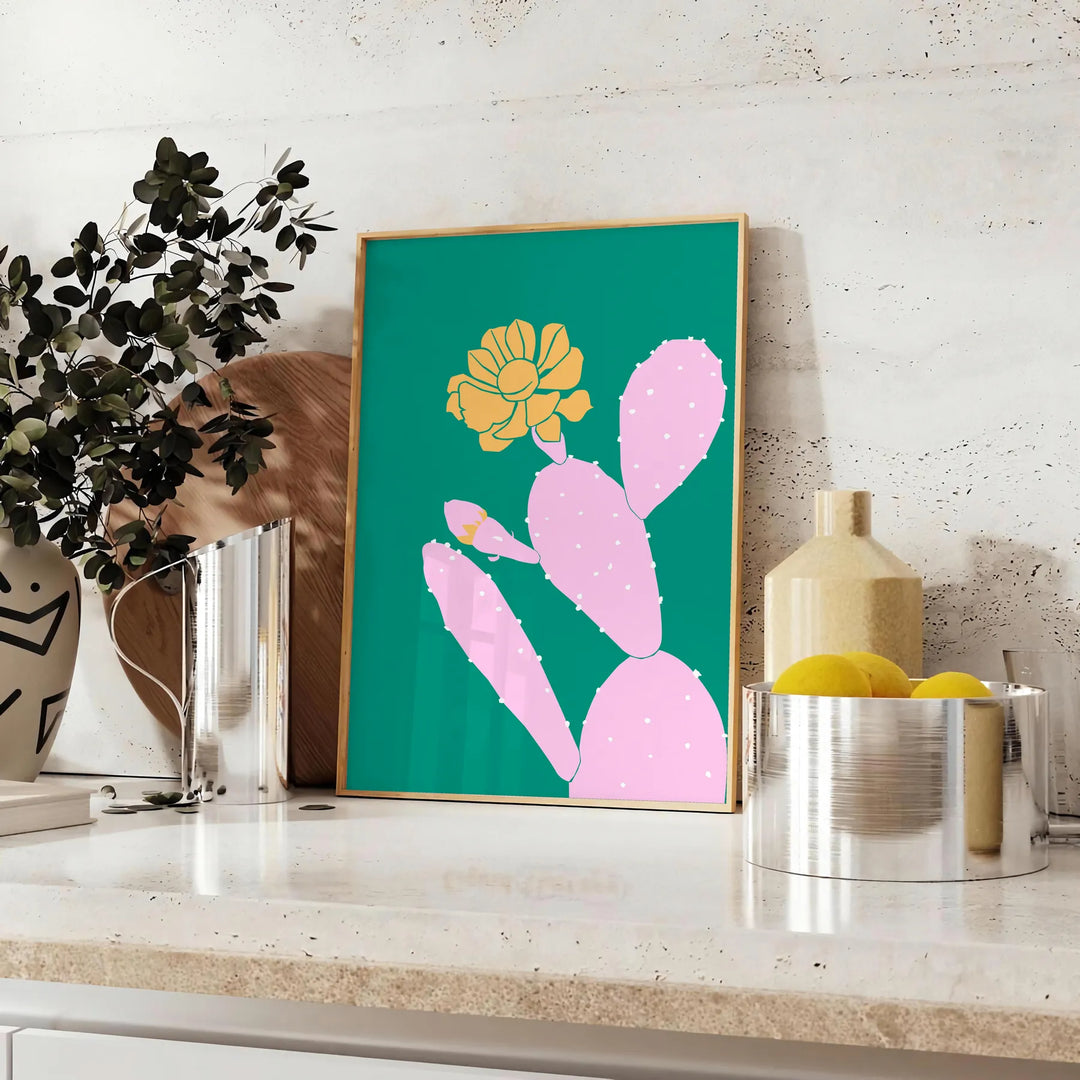 A whimsical illustration of a cactus with animal features in green and blue tones - styled on a counter with eucalyptus and a bowl of lemons