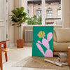 A whimsical illustration of a cactus with animal features in green and blue tones - in a Parisian living room with a sofa and a fig plant