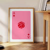 Colorful pop art style card design with bold orange and pink hues - beside a round wooden side table with books