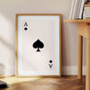 A sleek gray and black poster featuring a modern card design with space elements - beside a round wooden side table with books