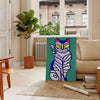 A modern art depiction of a cat in abstract shapes with green and blue tones - in a Parisian living room with a sofa and a fig plant