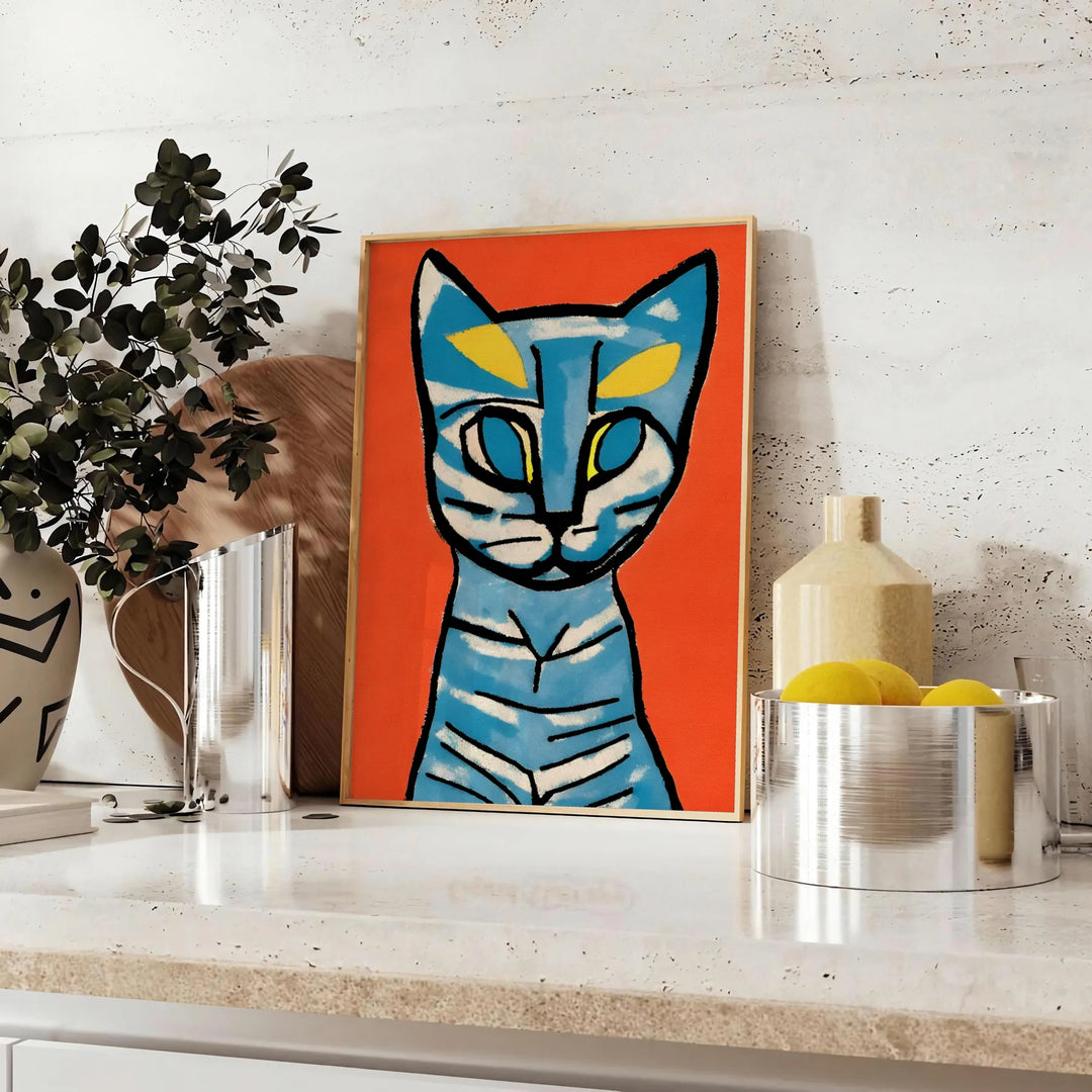 A modern art print featuring a stylized cat in blue and brown tones - styled on a counter with eucalyptus and a bowl of lemons